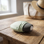 Close-up of compact silicone sunscreen roller with matte silicone head on wooden surface, highlighting its size and design.